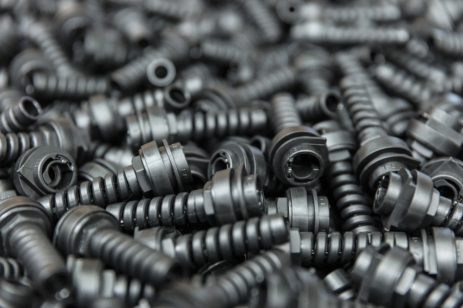 Nahaufnahme eines Haufens gerippter schwarzer Kunststoffteile.