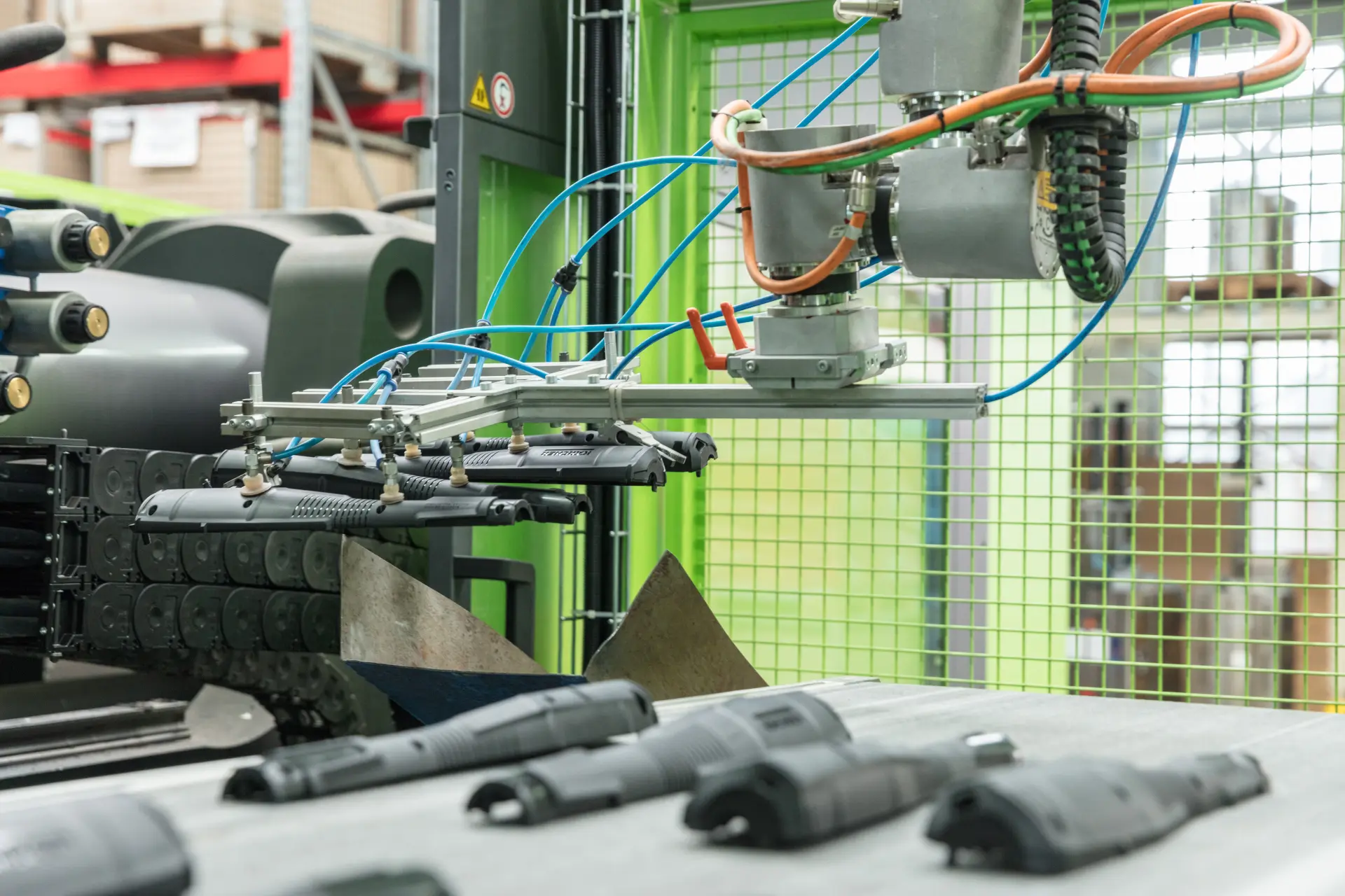 Roboter-Greifer mit Saugnäpfen bewegt Kunststoffteile auf einer Fertigungslinie.