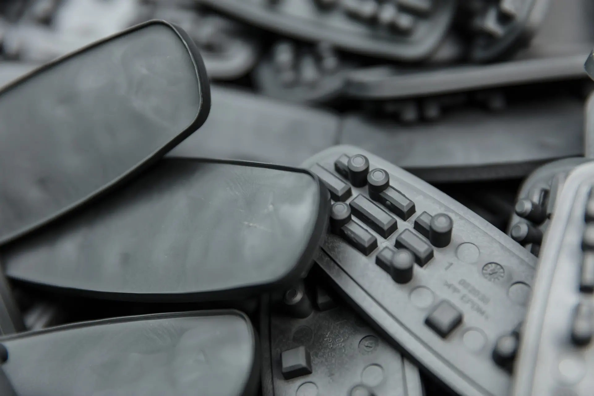 Nahaufnahme eines Haufens flacher Gummi-/Kunststoffteile mit kleinen Tasten. 